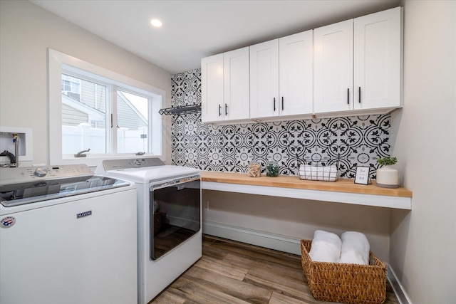 laundry room with cabinets, hardwood / wood-style floors, and washer and clothes dryer