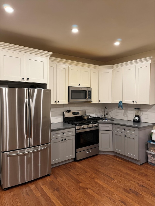 kitchen featuring white cabinetry, appliances with stainless steel finishes, gray cabinetry, and dark hardwood / wood-style flooring