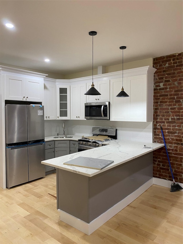 kitchen with kitchen peninsula, white cabinets, and stainless steel appliances