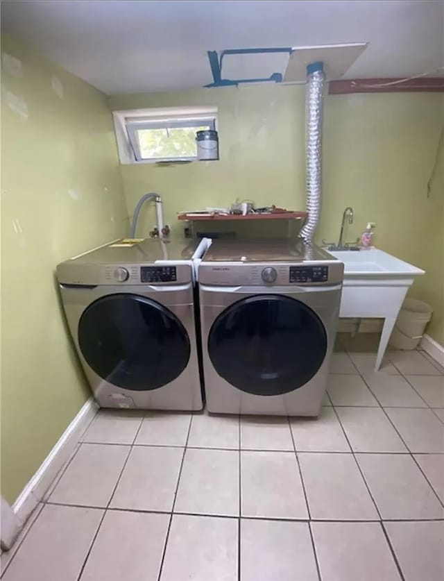 clothes washing area with light tile patterned flooring and separate washer and dryer