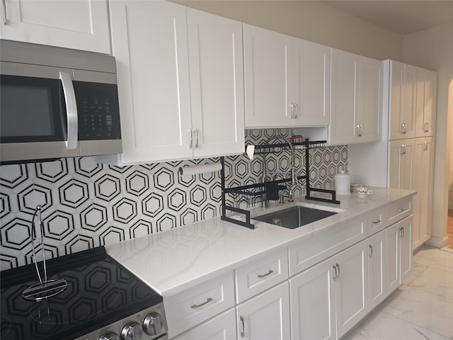 kitchen featuring appliances with stainless steel finishes, sink, white cabinets, and backsplash