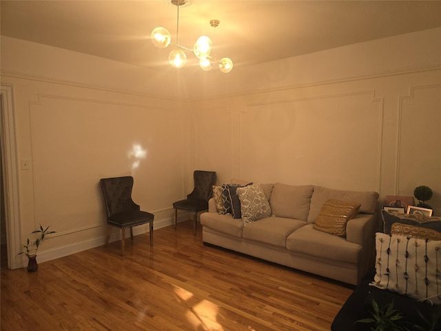 unfurnished living room with wood-type flooring and an inviting chandelier