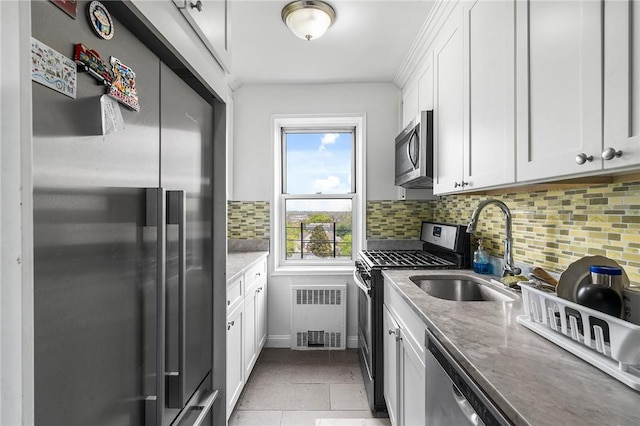 kitchen with white cabinets, appliances with stainless steel finishes, and tasteful backsplash