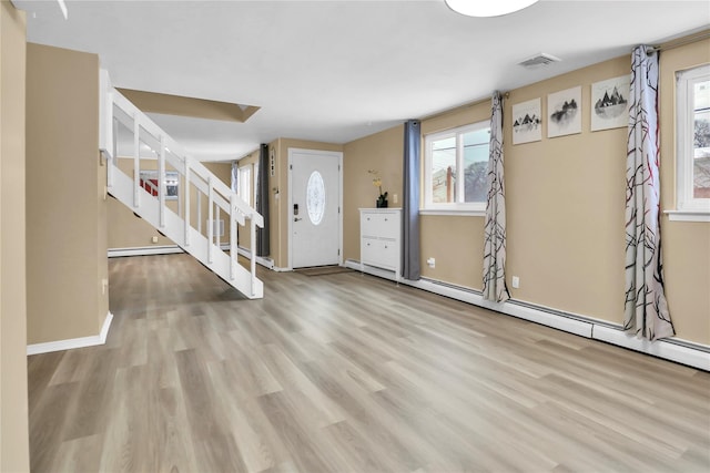 foyer with light hardwood / wood-style flooring and a baseboard heating unit