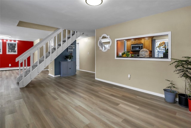 unfurnished living room with a baseboard heating unit and dark hardwood / wood-style flooring