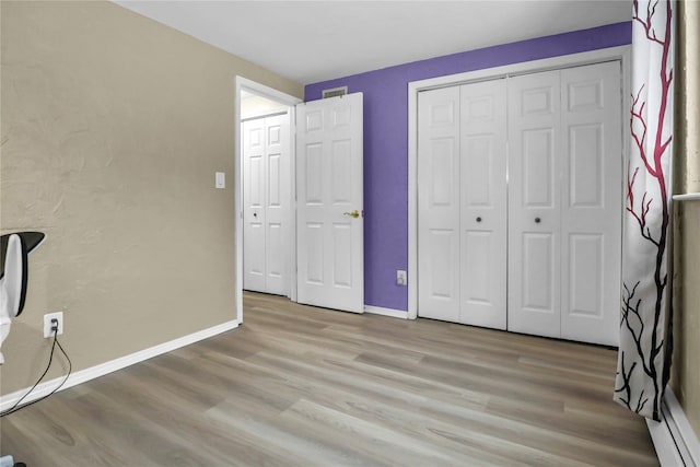 unfurnished bedroom featuring light wood-type flooring and a closet