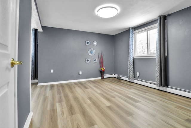 empty room featuring light hardwood / wood-style floors and a baseboard radiator