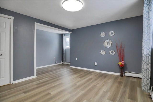 unfurnished room with light hardwood / wood-style floors and baseboard heating