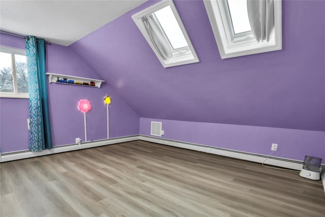 bonus room featuring light hardwood / wood-style floors and vaulted ceiling with skylight