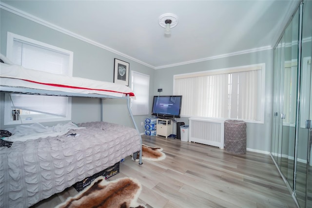 bedroom with hardwood / wood-style flooring, radiator heating unit, and ornamental molding