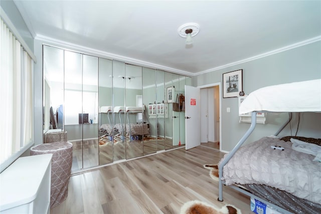 bedroom featuring ornamental molding, light hardwood / wood-style floors, and a closet