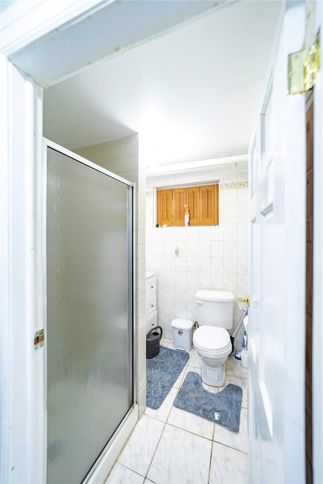 bathroom with tile walls, tile patterned floors, toilet, and walk in shower