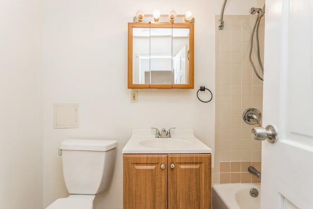 full bathroom featuring vanity, tiled shower / bath, and toilet