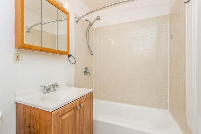 bathroom with tiled shower / bath and vanity