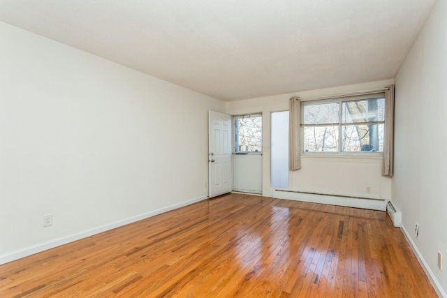 unfurnished room with wood-type flooring and a baseboard radiator