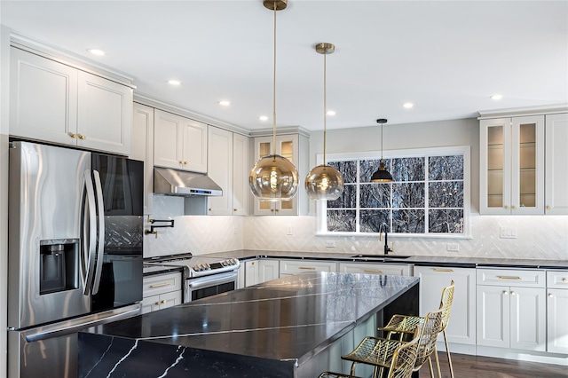 kitchen with sink, stainless steel appliances, pendant lighting, and decorative backsplash