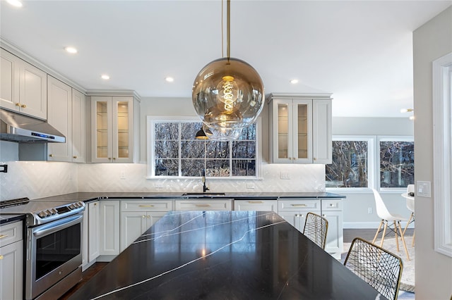 kitchen with tasteful backsplash, white cabinetry, hanging light fixtures, sink, and electric stove