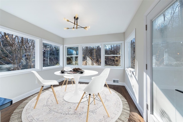 sunroom / solarium featuring a notable chandelier