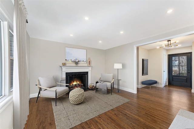 sitting room featuring dark wood-type flooring and a chandelier