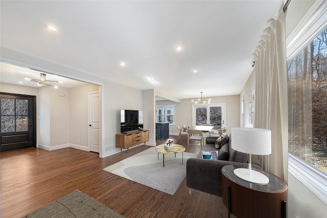 living room featuring dark wood-type flooring and a notable chandelier