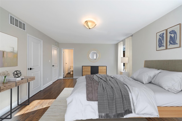 bedroom featuring connected bathroom and dark hardwood / wood-style flooring