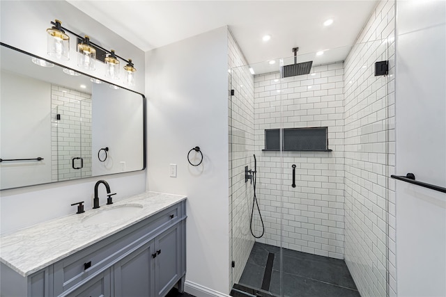 bathroom with a shower with shower door and vanity