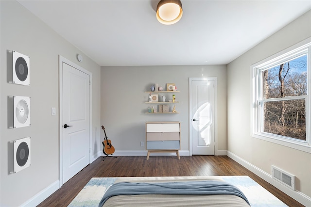 unfurnished bedroom with dark wood-type flooring and multiple windows