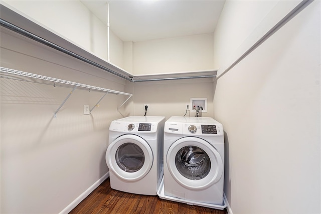 clothes washing area with washer and dryer and dark wood-type flooring