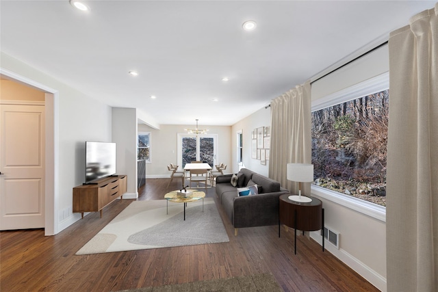 living room featuring dark hardwood / wood-style flooring and a chandelier