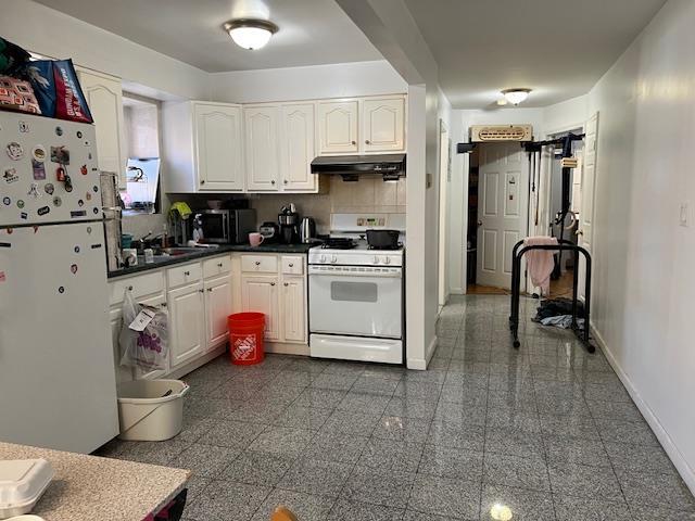 kitchen featuring white cabinetry, white appliances, and backsplash