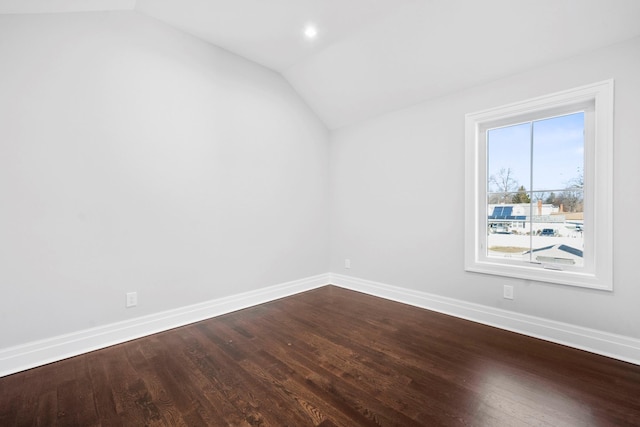 empty room with wood-type flooring and vaulted ceiling