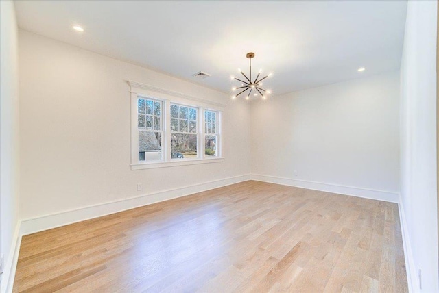 unfurnished room featuring visible vents, a notable chandelier, light wood-style flooring, and baseboards