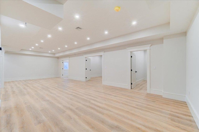 below grade area with light wood finished floors, visible vents, and recessed lighting