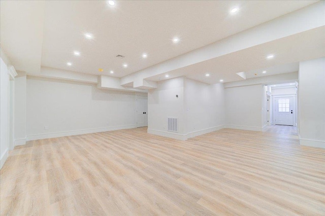 below grade area featuring recessed lighting, light wood-type flooring, visible vents, and baseboards