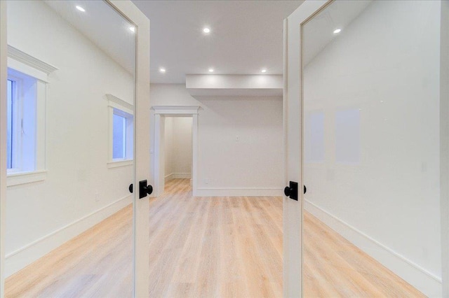 interior space with baseboards, wood finished floors, and recessed lighting