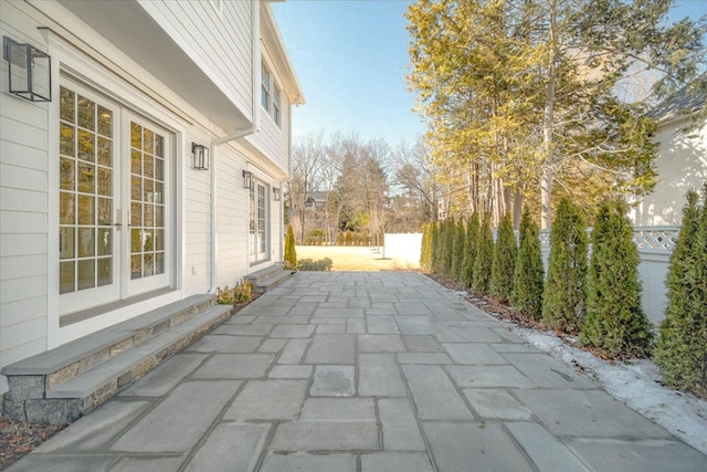 view of patio featuring entry steps, french doors, and fence