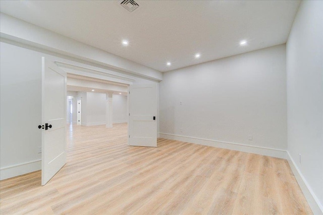 empty room featuring baseboards, light wood-type flooring, visible vents, and recessed lighting