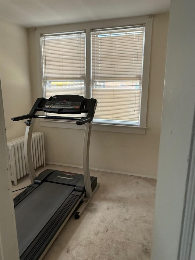 exercise area with light colored carpet and radiator