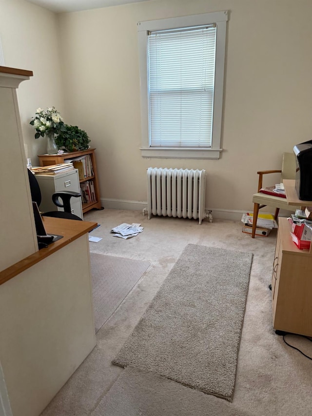 office space with radiator heating unit and light colored carpet