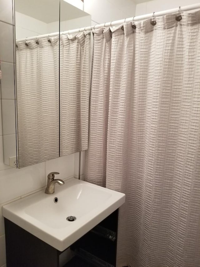 bathroom featuring curtained shower and vanity