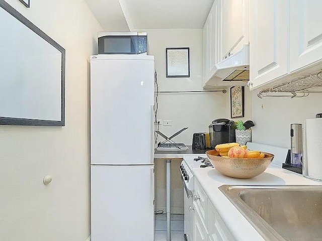 kitchen with white cabinetry and white fridge