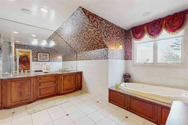 bathroom featuring vanity, tile patterned flooring, a tub, and tile walls