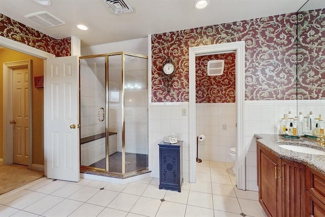 bathroom with tile patterned flooring, vanity, tile walls, and toilet