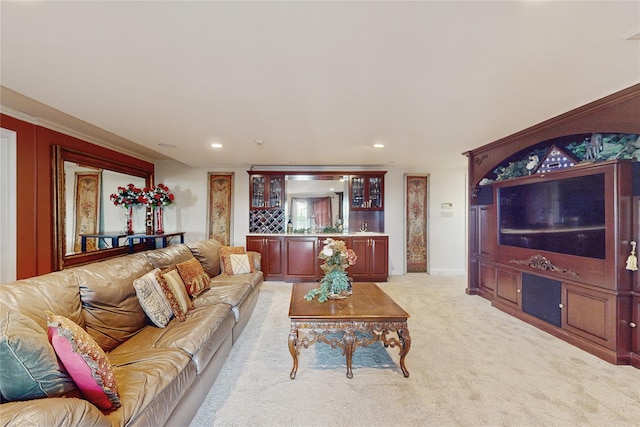 carpeted living room with indoor bar and ornamental molding