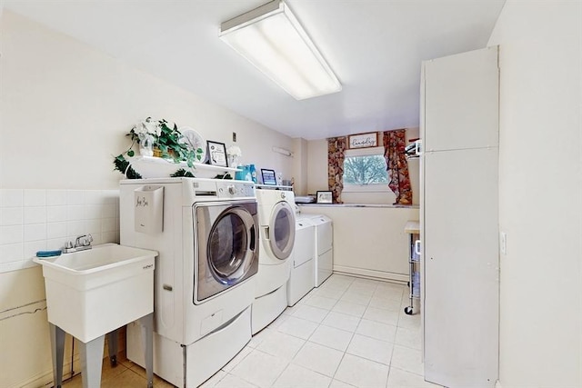 clothes washing area featuring washer and dryer and light tile patterned flooring