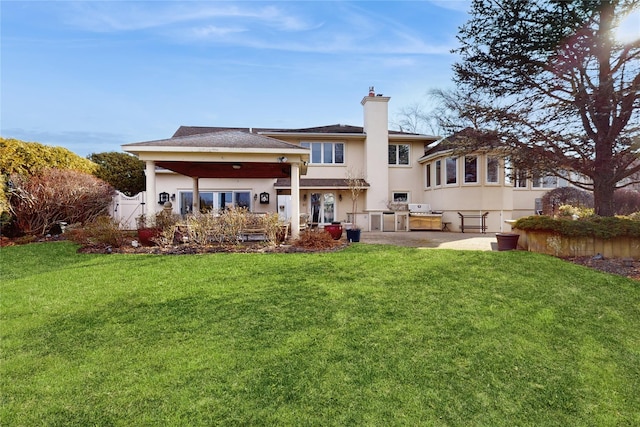 rear view of house featuring a yard, exterior kitchen, and a patio area