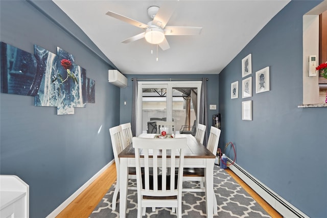 dining room featuring ceiling fan, baseboard heating, hardwood / wood-style floors, and a wall mounted air conditioner