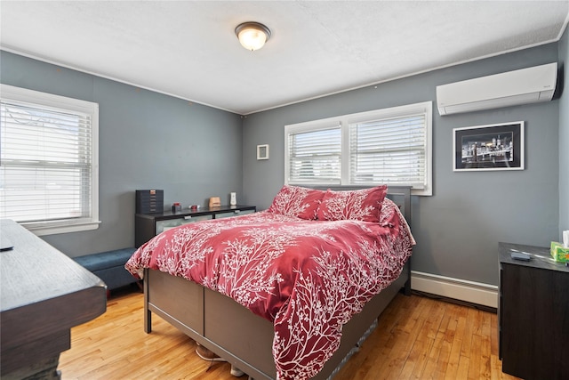 bedroom with an AC wall unit, a baseboard radiator, and hardwood / wood-style flooring