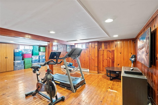 exercise room featuring light wood-type flooring and wooden walls