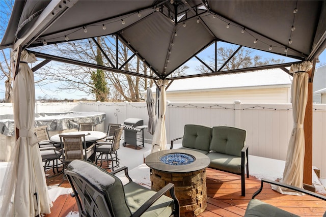 snow covered patio with a wooden deck, grilling area, and an outdoor living space with a fire pit